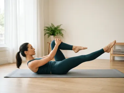 Eine Frau in petrolgrünem Sportoutfit führt die Pilates-Übung „Single Leg Stretch" auf einer grauen Matte aus – Oberkörper leicht angehoben, ein Bein angewinkelt an die Brust gezogen, das andere gestreckt. Im Hintergrund ein minimalistischer heller Raum mit Farnpflanze und Holzboden.