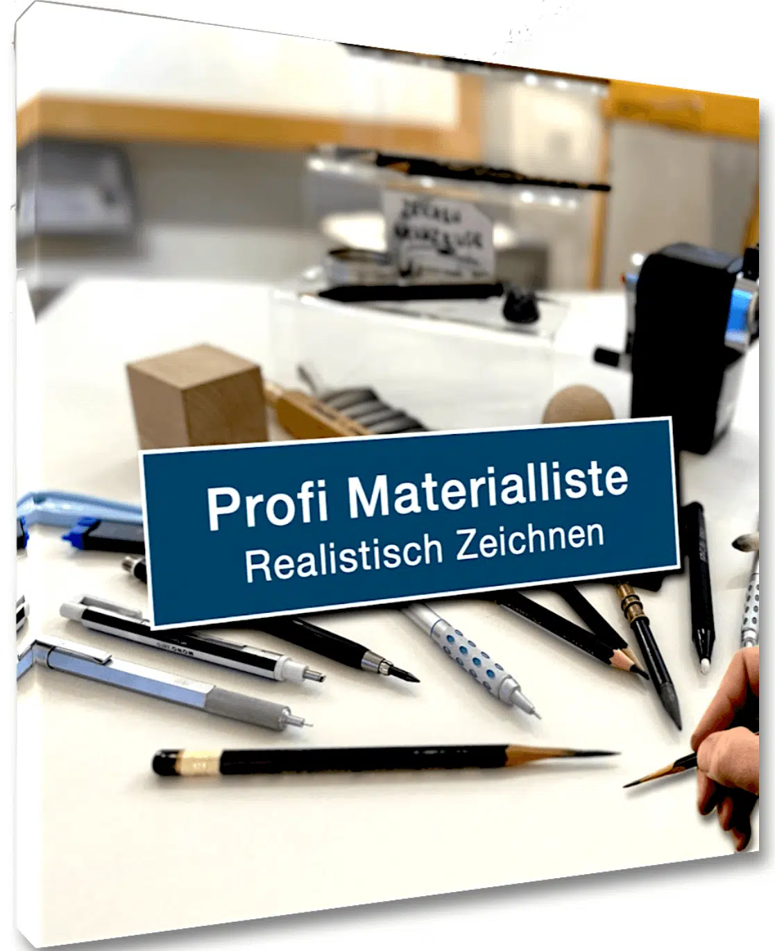 Cover eines Dokuments mit dem Titel „Profi Materialliste – Realistisch Zeichnen" auf blauem Label. Im Hintergrund eine Aufsicht auf verschiedene professionelle Zeichenutensilien auf weißer Fläche: Druckbleistifte, Fineliner, Radierstift, Bleistifte verschiedener Härtegrade, ein Spitzer und weitere Zeichenwerkzeuge. Eine Hand hält am rechten Rand einen feinen Pinsel.